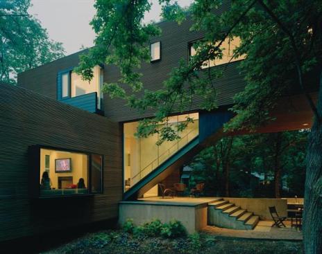 A rainscreen cladding of Brazilian redwood provides a textural contrast with the glass-enclosed staircase. 