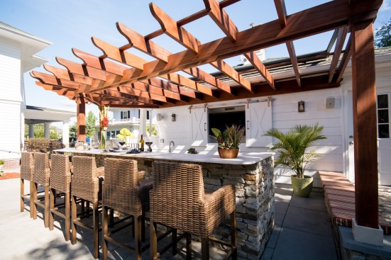 Fall River: Rhode Island–based firm Insperiors transformed this traditional New England backyard into a complete outdoor living space with an array of stainless steel appliances, bar-height seating, and a lounge area for a family of five.