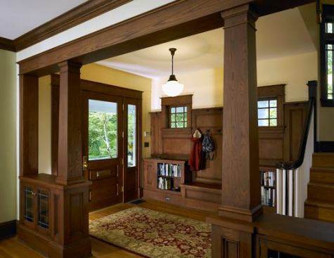 "We created spaces and details in the house that were consistent with the language of the home, while transforming it to serve a 21st century family's needs," says architect Wiedemann. In the foyer, custom millwork created cubbies for storage, a bench, and window and banister moldings.
