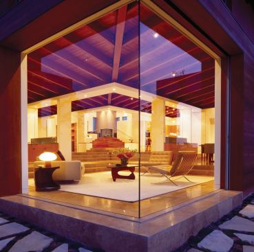 Continuous travertine floors and a butt-joined glass corner help unite the home's interiors and exteriors.