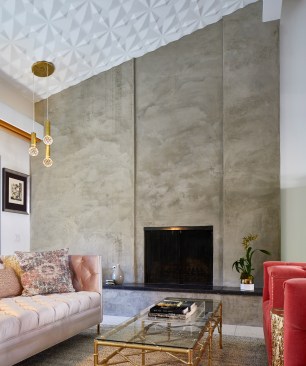 Resurfaced with hand troweled soft gray plaster, the fireplace anchors itself in the airy living space adorned with sculptural ceiling tiles.