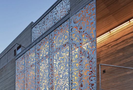 Waterjet-cut metal screens protect the double-height windows from hurricane-force winds and counterpoint the house’s rigid geometry.