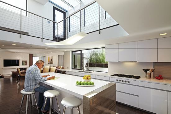 The kitchen opens onto a bamboo-screened deck and to the sky, via wall and roof windows above.