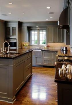 Custom cabinets are painted in a warm metallic pewter and fully integrated with the modlings, lending a sense of sophistication and unifying the surfaces.