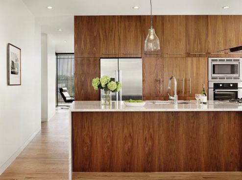 The project team used richly-grained walnut cabinetry and exterior wood screens to warm up the modernist spec homes. 