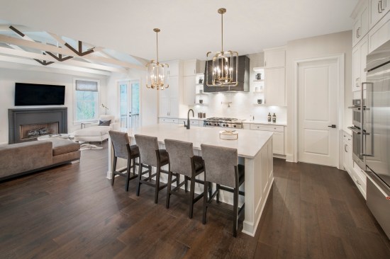 The kitchen features mixed metal accents with yellow gold light fixtures, satin nickel cabinet hardware, and matte black sink fixtures.