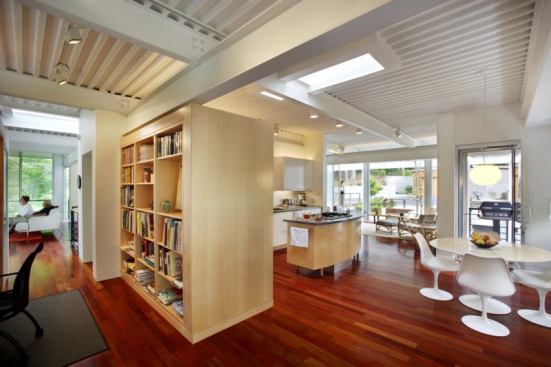 Utility functions cluster at the center of the plan, leaving the perimeter free for glass walls.