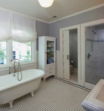 The all-new master bath is reclaimed from the original sleeping porch, whose influence remains in the large custom windows. The claw-foot tub was found at a salvage store.