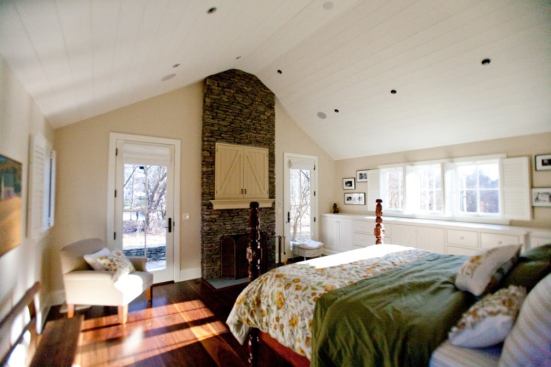 The ground-floor master suite, situated to the side of the house's silo, ensures the owners the ability to remain in their home as they age, providing for the possibility of mobility changes. More hayloft doors conceal the room's television.