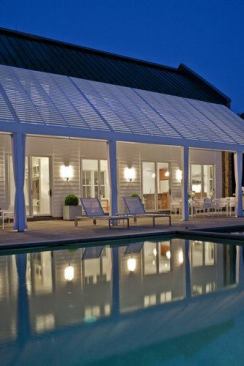 Sliding doors connect first-floor living, an office, and a pool bath to an expansive bluestone deck, the pool, and an integrated spa