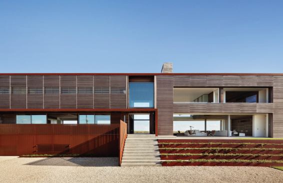 Large open spaces carved from the building’s bar-like form create view channels between the beach and the pond.