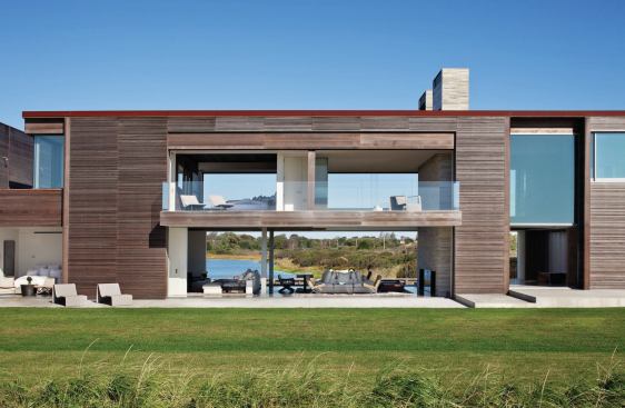 Nesting lift-slide doors turn a master suite into a tree house-like platform over the living and family rooms in Sagaponack, N.Y.
