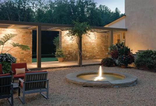The gravel courtyard, tucked into the void between the house and garage/guest quarters, is the social hub