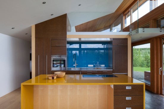 The bright yellow countertop creates a striking contrast to the dark wood finishes in this kitchen. Project: Big Little Rock by MINARC