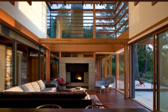 The house's primary living spaces and bedrooms in a volume mainly of wood and glass are to the West of the steel structure, with wide scenic views.