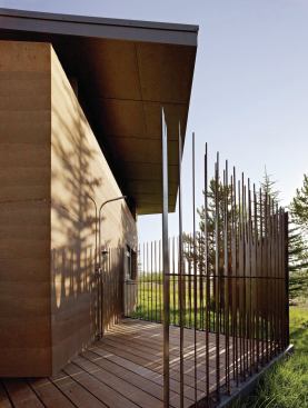 “The client really wanted an outdoor shower and that was part of the program of the entire building,” says architect Jennifer Mei.  “This was the most private spot on the site and it faces the mountains, so we placed a mostly open outdoor shower here. The idea of a fence extending from the rammed earth wall was something that appealed to us because it wasn’t solid but does create privacy.” 