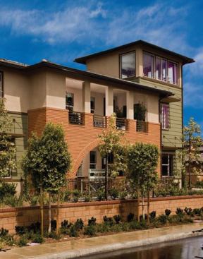 The solution was to blend the two aesthetics into an updated Prairie style featuring long, horizontal runs of red brick and wood veneer siding, hipped roof forms, and boldly outlined window sashes. An asymmetrical tower element breaks the mass, making the roofline more dynamic.