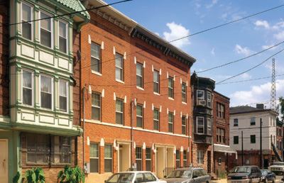 Making way for the renewal effort first required the demolition of the Martin Luther King Plaza Towers, a 594-unit public housing project on six acres in the Hawthorne neighborhood. A virtual icon of urban blight, the towers had become symbolic of being poor in Philadelphia. By the time a decision was made to raze the dilapidated structures, more than 200 units were already uninhabitable due to disrepair. Restoring vitality to the neighborhood subsequently hinged on two pivotal elements: an urban square invoking the principles that drove William Penn's original design for the city, and infill housing that was consistent with the native dwelling type, historic row homes.