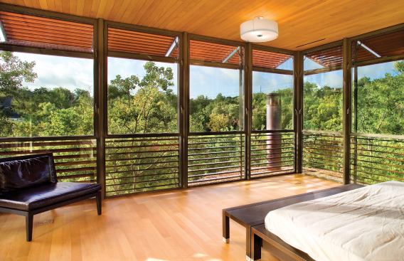 With three walls of glass, the master bedroom seems to hover above the trees. It's an ideal lookout for observing the egrets, cranes, and swans that pass through the site on their migrations.