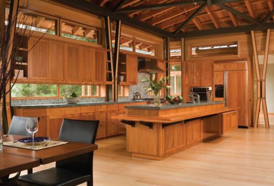 Low cabinets delineate cooking, dining, seating, and office areas in an otherwise open space.
