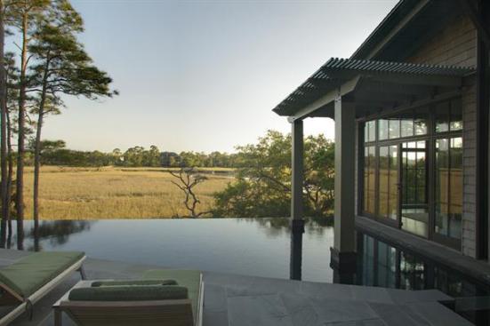 The disappearing-edge pool links the master bedroom to the home's main public spaces. It faces south, toward a tranquil marsh.
