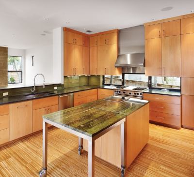 This kitchen lies athwart a row house-like floor plan, and its strip flooring underscores the building's longitudinal layout. The same material lines the knee space at the family room counter. Cooler in palette, the master bath employs linearity to soothing effect.
