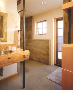 The bathroom is sectioned off so more than one person can use it at a time. The sauna is tucked away behind the shower. The soaking tub, behind the linen closet wall, offers views across the courtyard to the mountains.
