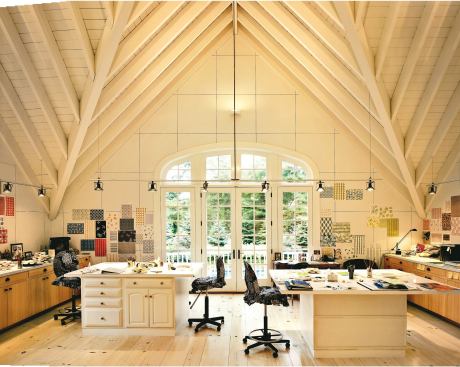 A wooden walkway leads from the house’s back patio down to the water (opposite, bottom). The high-ceilinged design studio (this page) occupies the upper story of the pool house (opposite, top).