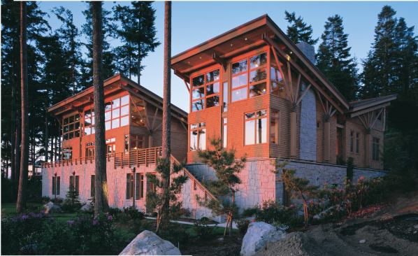 The soaring second floor of the house, clad in semi-transparent stained cedar shingles, sits atop the granite-sheathed lower level.