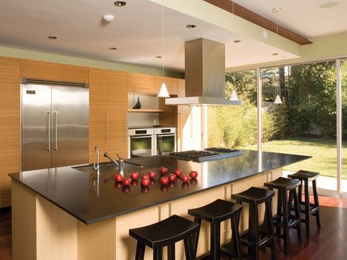 Its interior walls lined with flush bamboo storage cabinets, the kitchen concentrates work space at its large, granite-topped island.