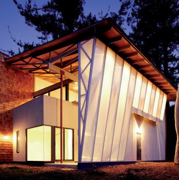 After dark, a glowing wall of prefab roof trusses enclosed in translucent plastic lights up a Santa Barbara, Calif., guest apartment.