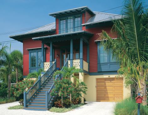 Impact-resistant windows shore up the home's hurricane defenses. The dark paint colors and simple materials of the English Caribbean style fit the context of its historical Gulf Coast location.