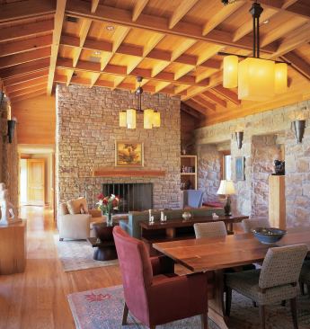 In the living and dining room, pecan floors and cypress ceilings unite with sandstone walls to provide a warm, intimate atmosphere.