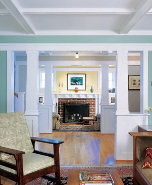 Sturdy, white-painted columns and wide openings between rooms lend the house a sense of solidity and proportion.
