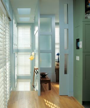 Glazed panels and pocket doors let the library and living area share light. 