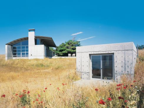 As happy to be buried as to be exposed, concrete helps this weekend compound achieve a deep connection to its hillside site. For more of this house, turn the page. 