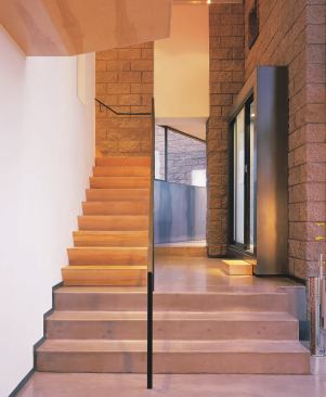 Split-face concrete block provides a rugged contrast to smooth, pigmented slab floors and birch millwork.