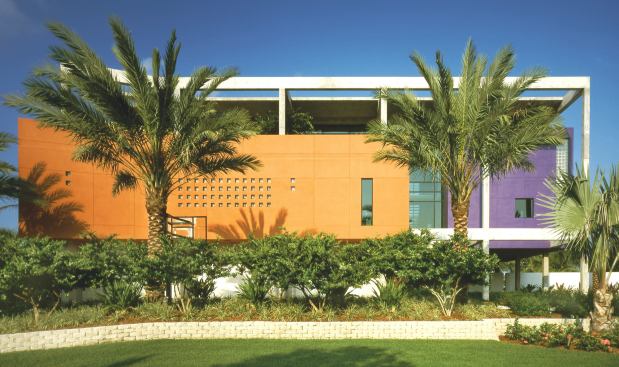 This Gulf Coast family home supports its colorful collection of stuccoed living modules with a post-and-beam frame of exposed structural concrete.