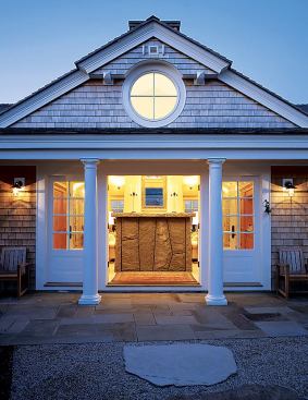 The imposing granite fireplace, visible from the house's front entry, anchors the living room.