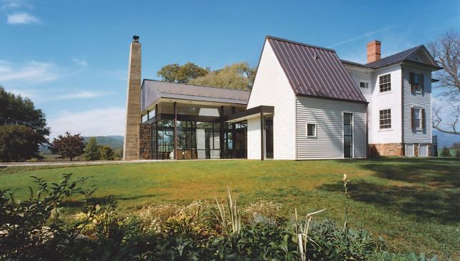 The new parts of the project—a glass pavilion, a tall clapboard portion, and an entry hall and circulation space—all pay homage to the existing farmhouse through their forms and materials.