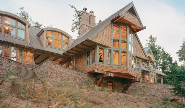 The home's two-story living room cranes out over a masonry retaining wall to capture views of the Strait of Juan de Fuca.