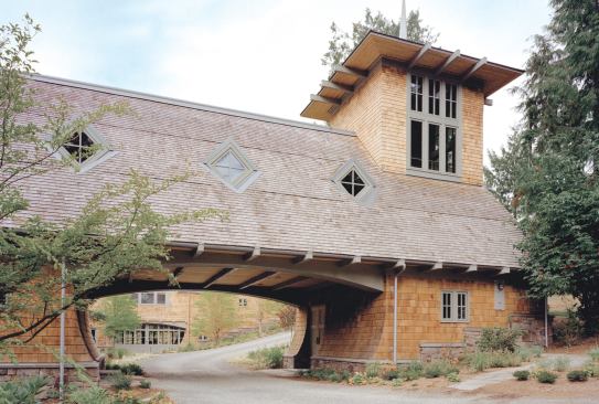 The driveway leads through an arched portal, a motif that recurs in the pool cabana.