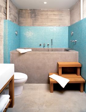 Like the new slab floor, the bathroom's cast-in-place concrete soaking tub is warmed by hydronic coils.