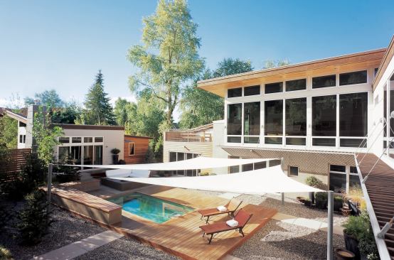 The design for this house revolves around a courtyard that contains the fire and water elements the clients required for multi-season enjoyment. To give the clients the easy-care landscape they desired, the architect designed a "floor" for the outdoor room entirely covered with an earthy combination of stone, wood, and concrete.