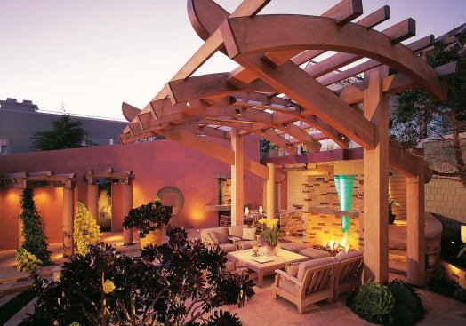 The focus of the outdoor living room is a stone and stacked-glass fireplace.