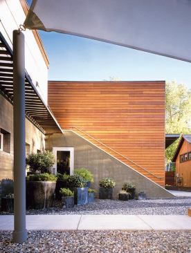 A rich collection of colors such as the charcoal stained concrete, tawny ipe wood, zinc planters, and black and gray gravel creates a dark palette that absorbs the sun's heat and warms the path from house to heated pool to fire pit and back again.