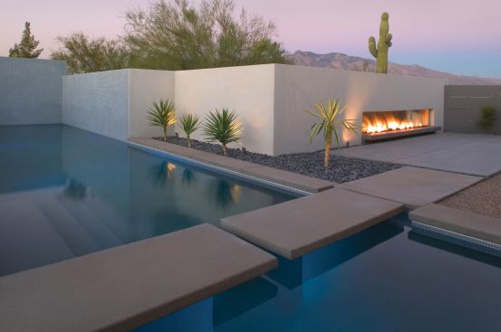 The long, lean shape of the fireplace emphasizes the home’s horizontal lines. A switch just outside the master bedroom door ignites the fireplace, which is simply a length of gas pipe with random holes punched into it.