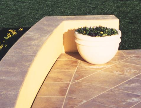Though it appears to be a narrow shadow, the dark line at the base of the wall near the planter is one of the drains that were carefully designed and installed to subtly "disappear" into the paving pattern.
