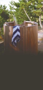 This Martha's Vineyard outdoor shower is oriented to the east to capture the Atlantic view and to allow the owners to take a shower after their morning run. The shower shares a bluestone terrace with a table for two, creating a little oasis for a small house.