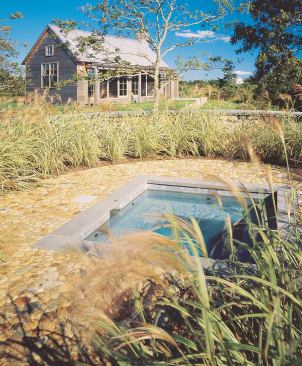 A round spa area is surfaced in big beach pebbles to evoke the foundation ruins of an imaginary old silo. 